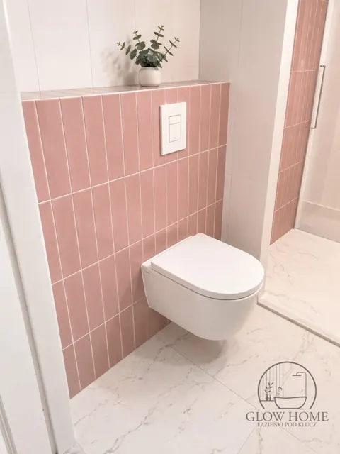 Różowe kafle metro za WC podwieszanym, jasna podłoga