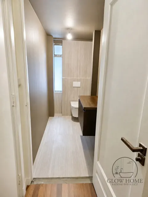 Wąska łazienka z drewnopodobną podłogą i WC podwieszanym